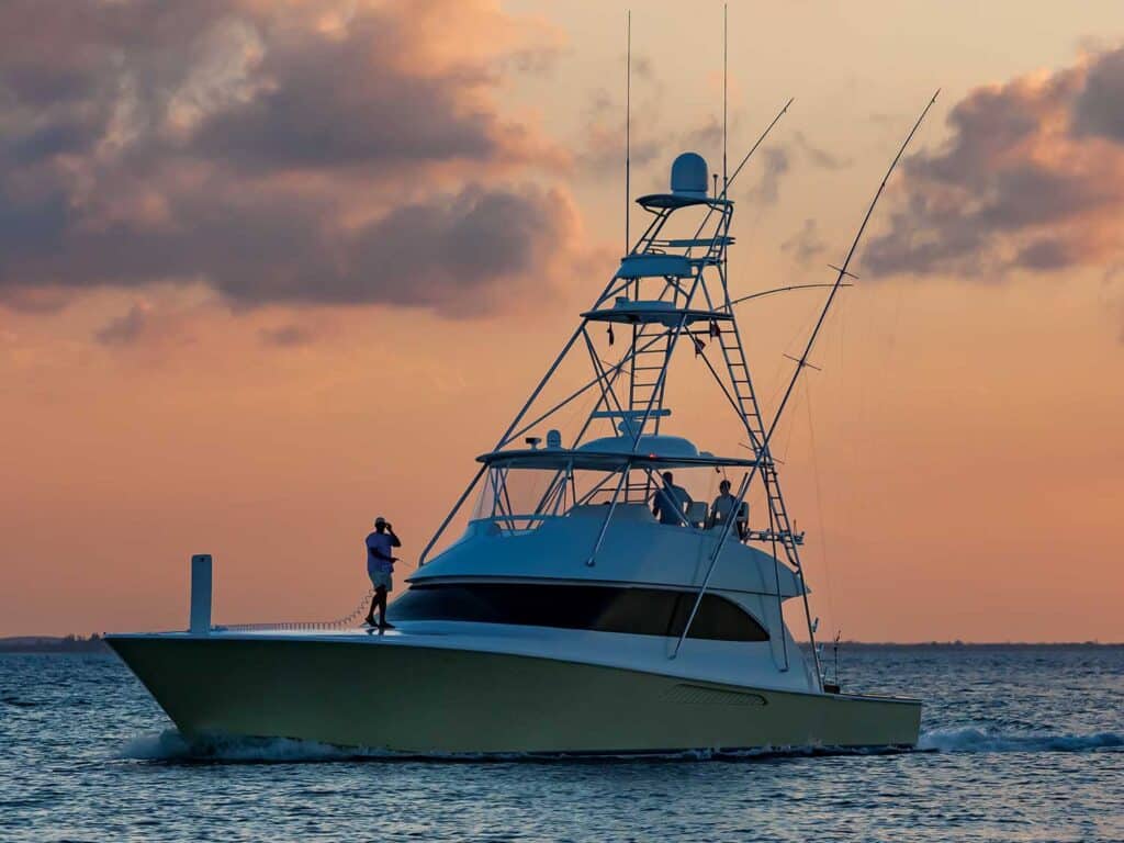 A sport-fishing boat on the water during sunset.
